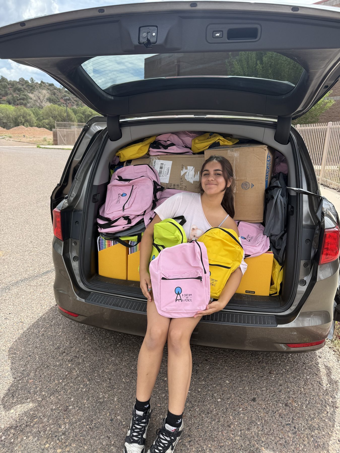 Nishka Makkar with a van full of packed backpacks ready for delivery